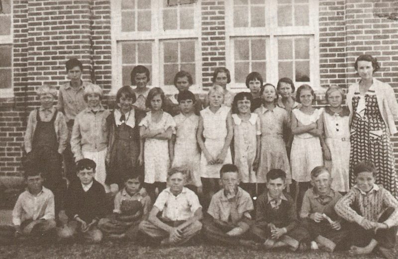 1935-1936 class photo taken in front of the schoolhouse.